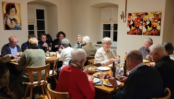 Etwa 15 Leute sitzen im Pfarrheim an den Tischen und essen gemeinsam.