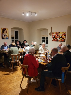 Etwa 15 Leute sitzen im Pfarrheim an den Tischen und essen gemeinsam.